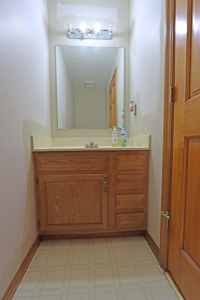 bathroom featuring baseboards, vanity, and tile patterned floors