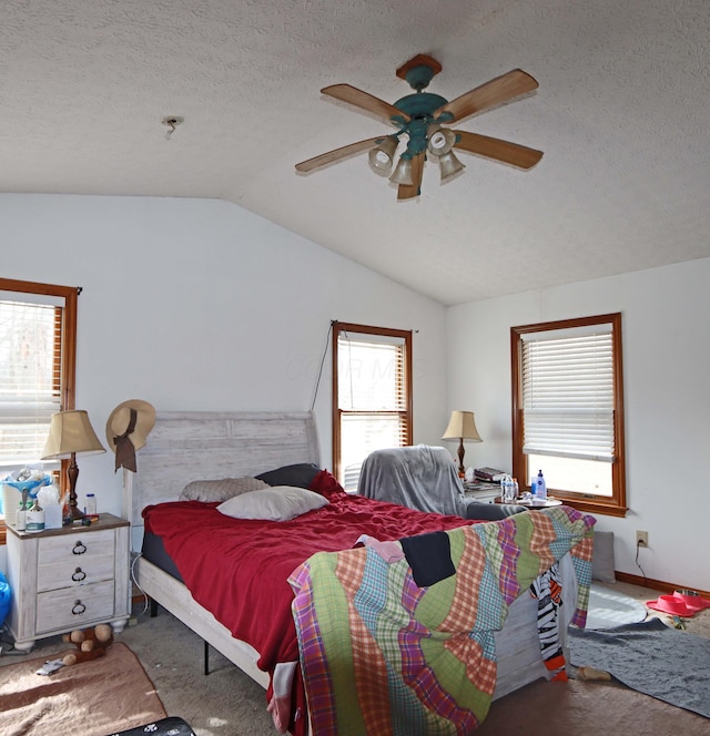 carpeted bedroom with lofted ceiling, multiple windows, ceiling fan, and a textured ceiling