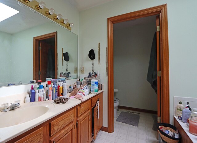 bathroom with toilet, vanity, and tile patterned floors