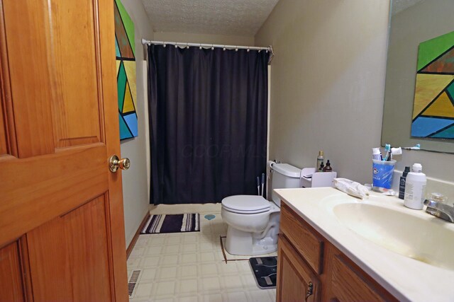 bathroom featuring a shower with shower curtain, toilet, vanity, a textured ceiling, and tile patterned floors