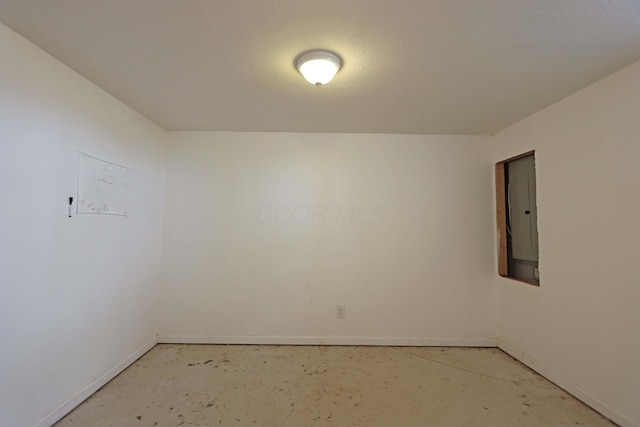 unfurnished room with electric panel and unfinished concrete floors