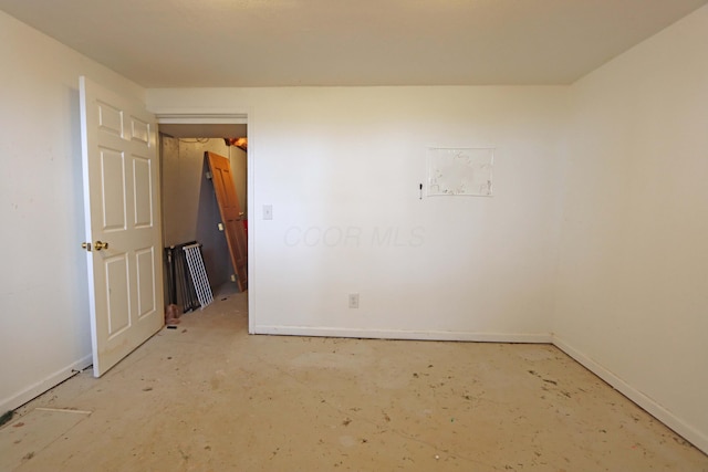 unfurnished room with baseboards