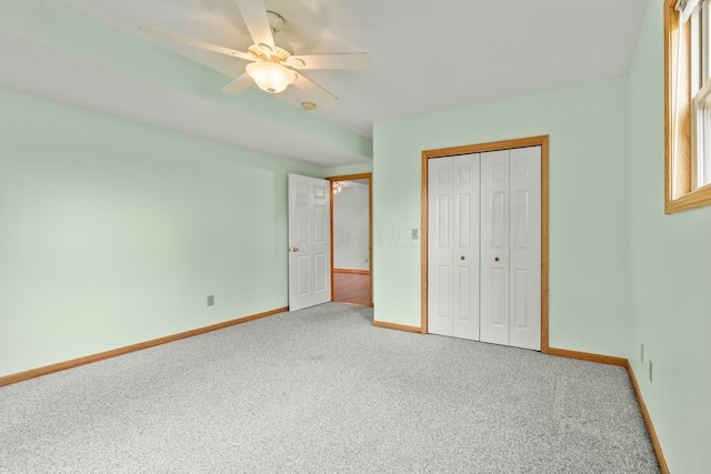 unfurnished bedroom featuring a closet, carpet flooring, a ceiling fan, and baseboards