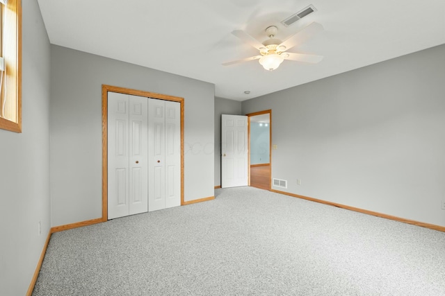 unfurnished bedroom featuring carpet, a closet, visible vents, and baseboards