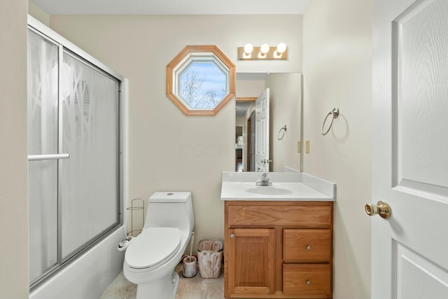 bathroom featuring toilet, bath / shower combo with glass door, and vanity