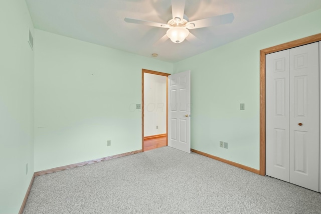 unfurnished bedroom with a closet, visible vents, carpet flooring, ceiling fan, and baseboards