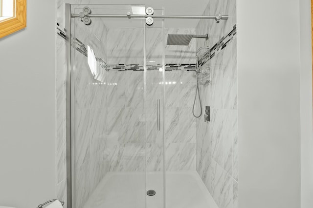 bathroom featuring a marble finish shower