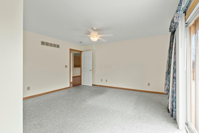 spare room with carpet floors, baseboards, visible vents, and a ceiling fan