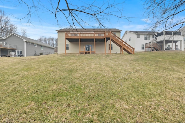 rear view of property with a lawn, stairway, and a wooden deck