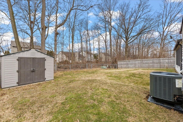 view of yard featuring an outbuilding, a fenced backyard, a shed, and central air condition unit