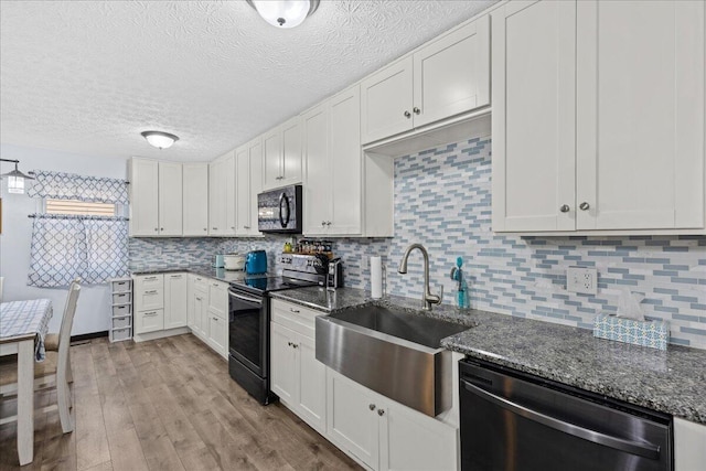 kitchen with electric stove, a sink, wood finished floors, black microwave, and dishwasher