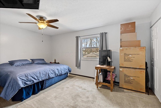 carpeted bedroom with a ceiling fan, a textured ceiling, and baseboards