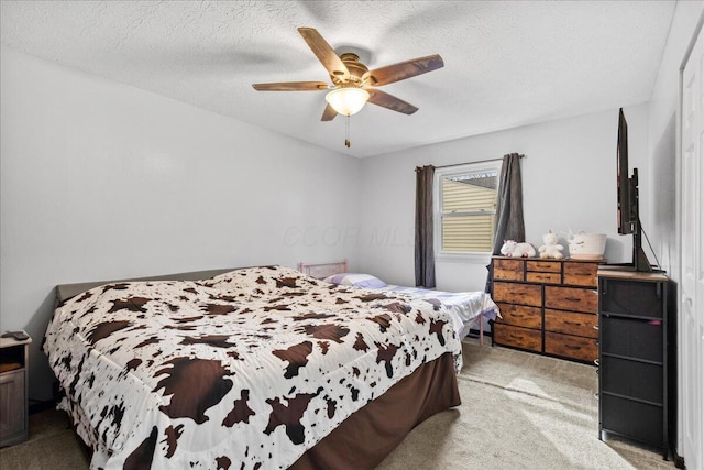 bedroom featuring light carpet, a textured ceiling, and a ceiling fan