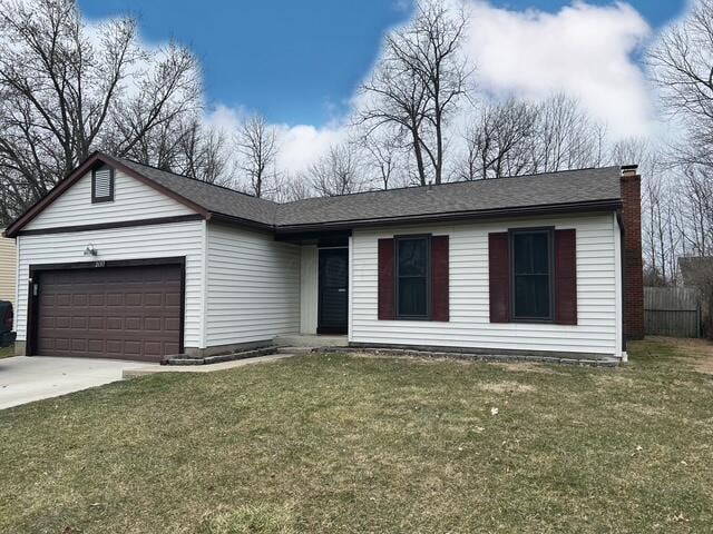 single story home with an attached garage, a chimney, concrete driveway, and a front yard