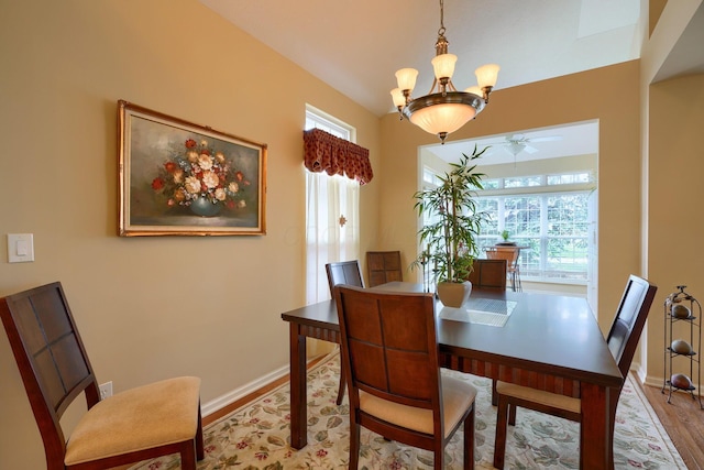 dining room with an inviting chandelier, a healthy amount of sunlight, baseboards, and wood finished floors