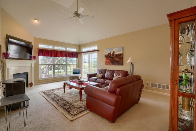 carpeted living area with a fireplace, visible vents, a ceiling fan, high vaulted ceiling, and baseboards