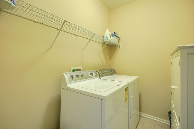 laundry room with washer and dryer, laundry area, baseboards, and light tile patterned floors