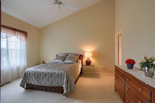 bedroom featuring baseboards, high vaulted ceiling, ceiling fan, and light colored carpet