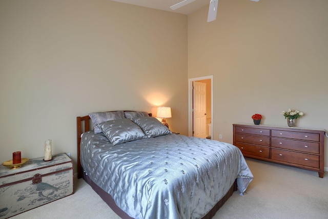 bedroom featuring light carpet and a towering ceiling