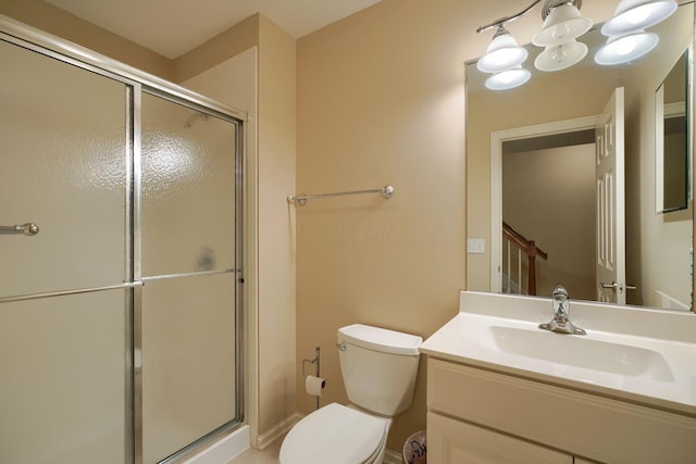 full bathroom with vanity, a shower stall, and toilet