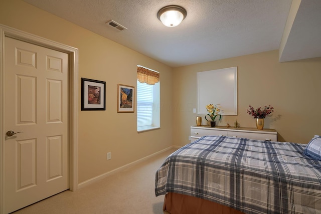 bedroom featuring light colored carpet, visible vents, a textured ceiling, and baseboards