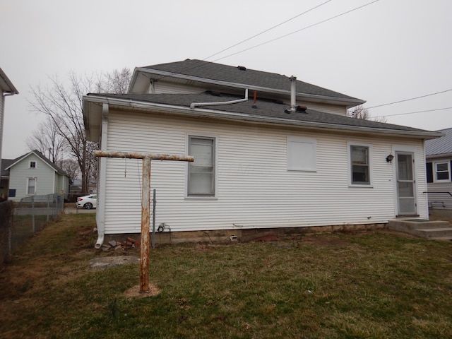 back of property featuring a yard and fence