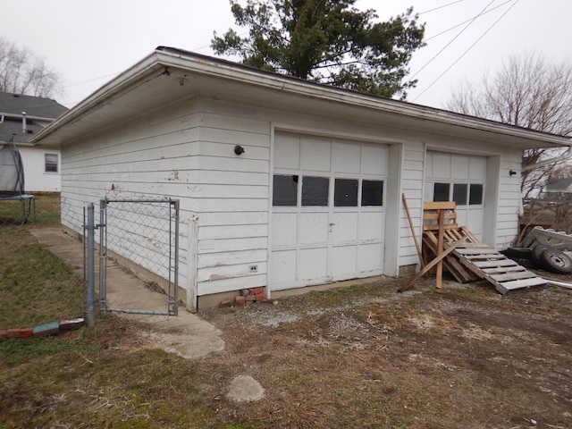 garage featuring a trampoline and a gate