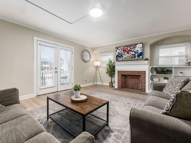 living area featuring french doors, ornamental molding, plenty of natural light, and wood finished floors