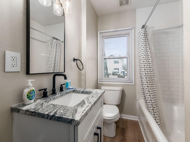 full bath featuring baseboards, visible vents, toilet, wood finished floors, and vanity