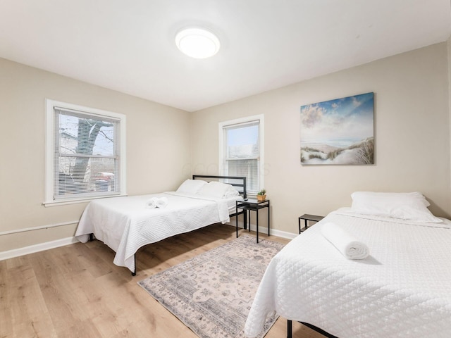 bedroom featuring light wood-style floors and baseboards