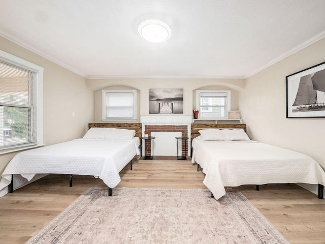 bedroom featuring ornamental molding and wood finished floors