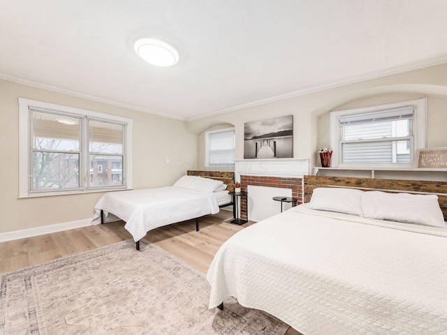 bedroom featuring ornamental molding, wood finished floors, and baseboards