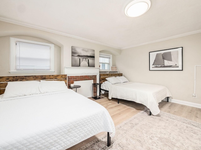 bedroom with ornamental molding, wood finished floors, and baseboards