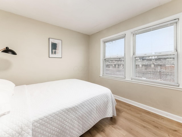 bedroom with baseboards and wood finished floors