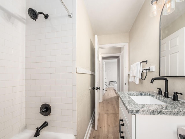 bathroom with bathtub / shower combination, wood finished floors, and vanity