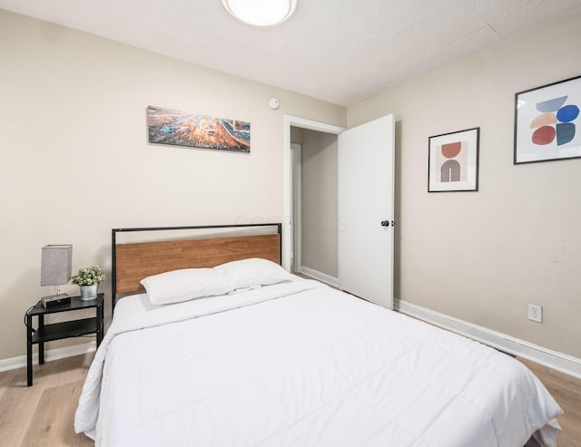 bedroom featuring baseboards and wood finished floors