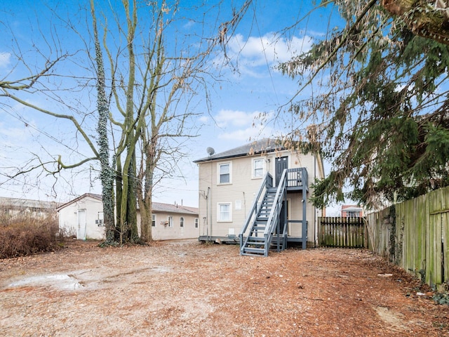 rear view of house with stairs and fence