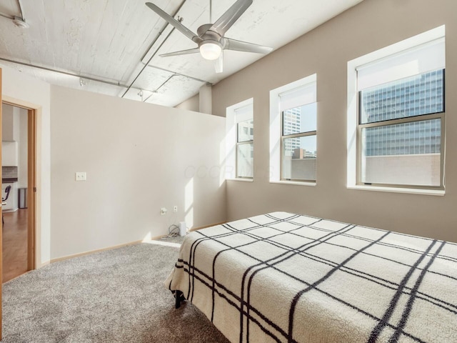 carpeted bedroom with washer / dryer, a ceiling fan, baseboards, and track lighting