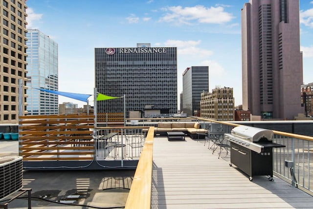 wooden terrace with central air condition unit, area for grilling, and a city view