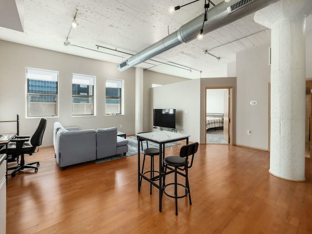 living room featuring track lighting, visible vents, and wood finished floors