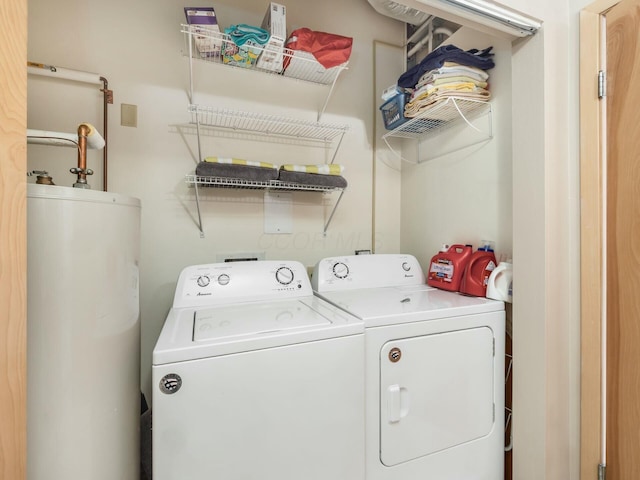 clothes washing area featuring laundry area, water heater, and independent washer and dryer