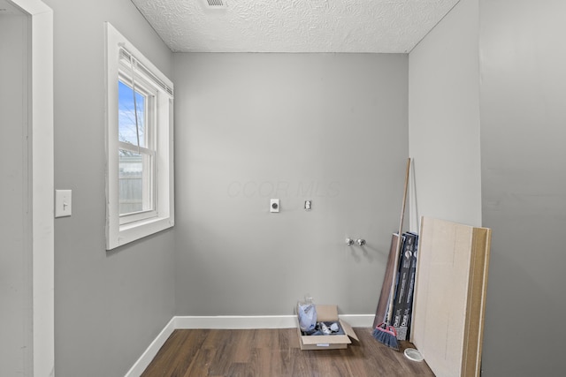 laundry room featuring laundry area, baseboards, dark wood-style floors, and a textured ceiling