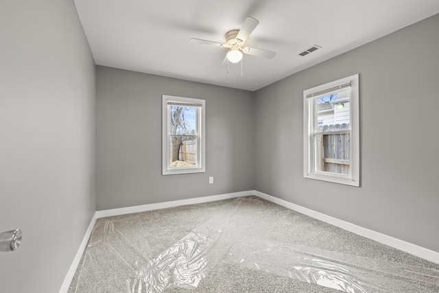 spare room with ceiling fan, carpet flooring, visible vents, and baseboards