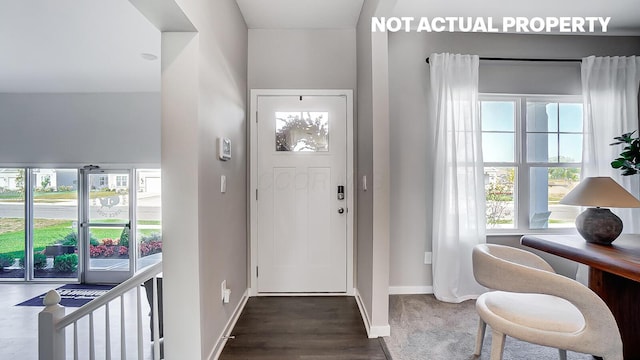 entrance foyer with dark wood-type flooring and baseboards