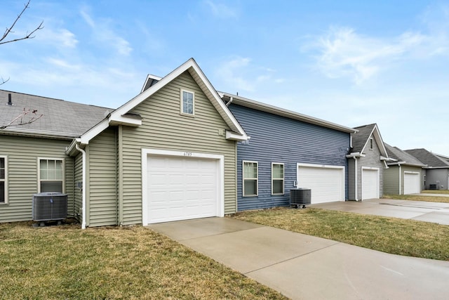 view of side of property featuring concrete driveway, a yard, and central AC unit