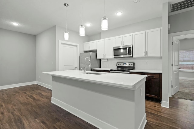 kitchen featuring a center island with sink, visible vents, stainless steel appliances, light countertops, and a sink