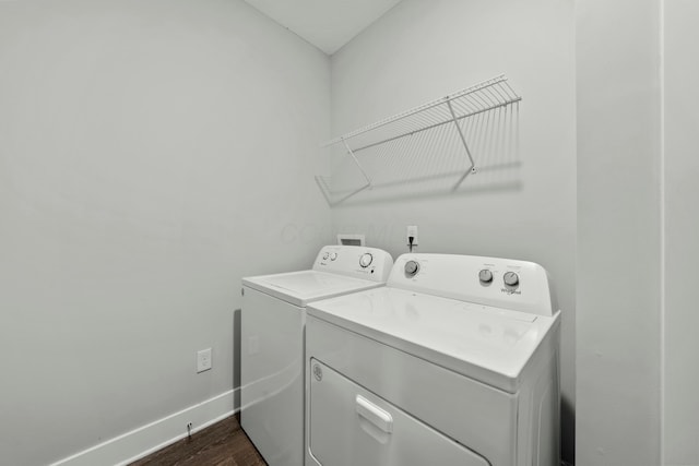 laundry room with laundry area, dark wood-type flooring, washing machine and dryer, and baseboards