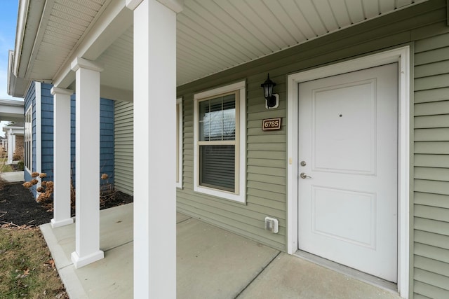 view of exterior entry featuring covered porch