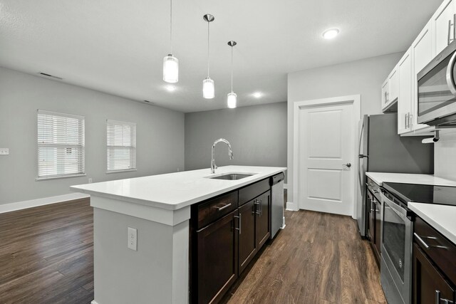 kitchen with dark wood-style floors, stainless steel appliances, a sink, and light countertops