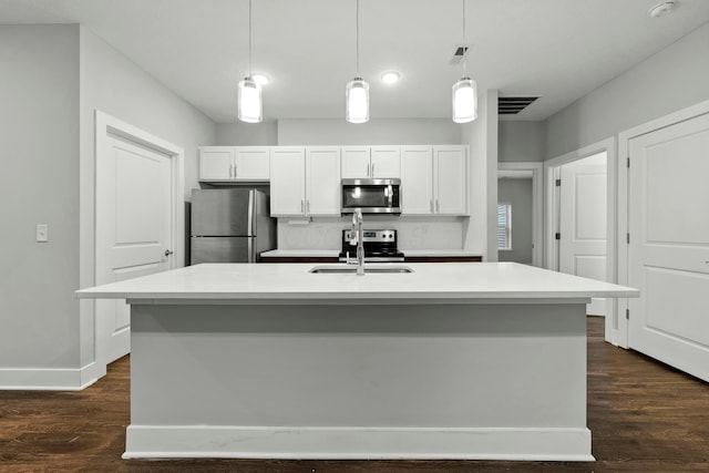 kitchen with dark wood-style floors, appliances with stainless steel finishes, white cabinets, and a sink